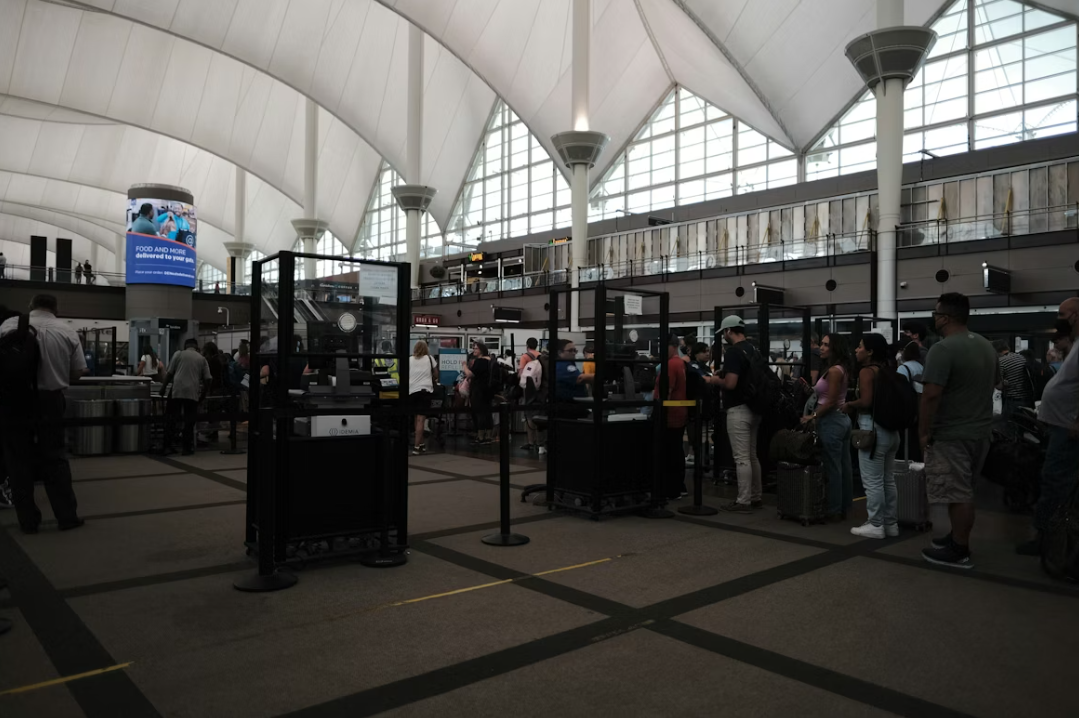 People queuing in a large room with a window at the top