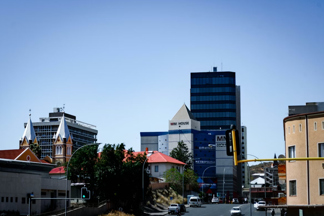 A city street with traffic next to tall buildings