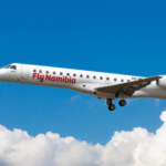 A large white jetliner flying in a blue sky with clouds
