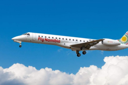A large white jetliner flying in a blue sky with clouds