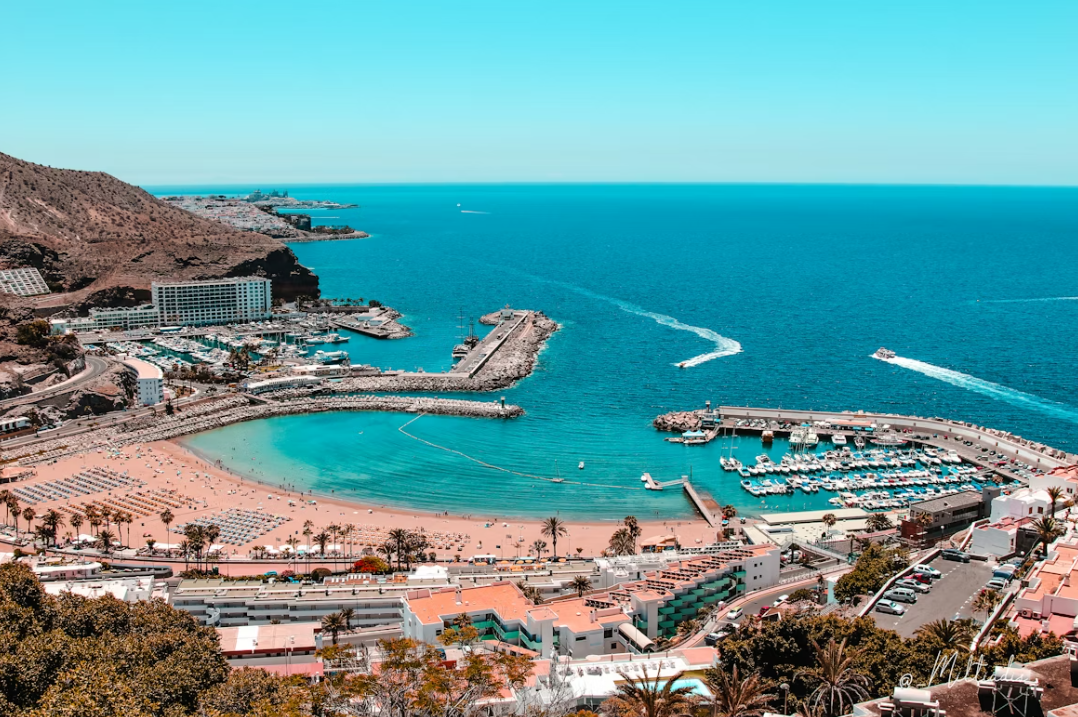 A beach next to the ocean with tall white buildings