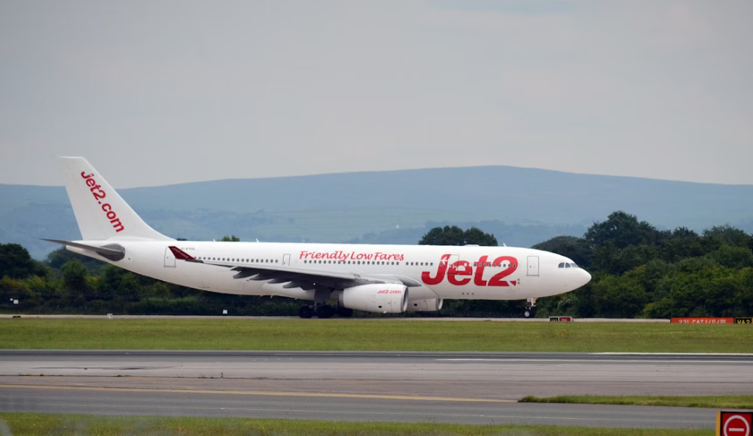 A large white jetliner sitting on an airport runway