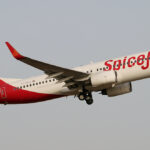 SpiceJet Boeing 737-800 flying in the grey sky upwards to the right. White and red livery.