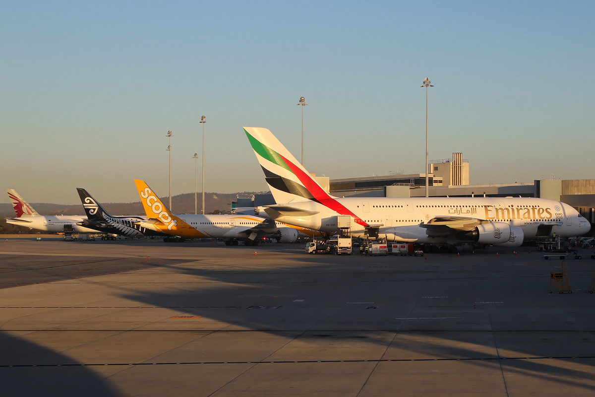 Planes that carry international flights lined up at Perth Airport, home to Routes Asia 2025, under a sunset.