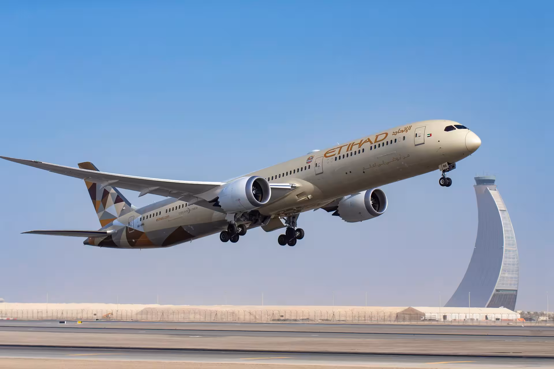 Etihad Airways B787 taking off against a blue sky, with a tall building in the background, the landing gear still out.
