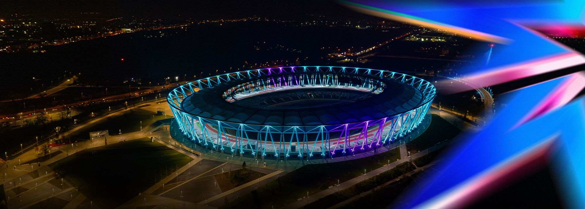 Exterior view of the National Athletics Centre in Budapest, at night.