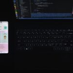 A smartphone laying next to a laptop