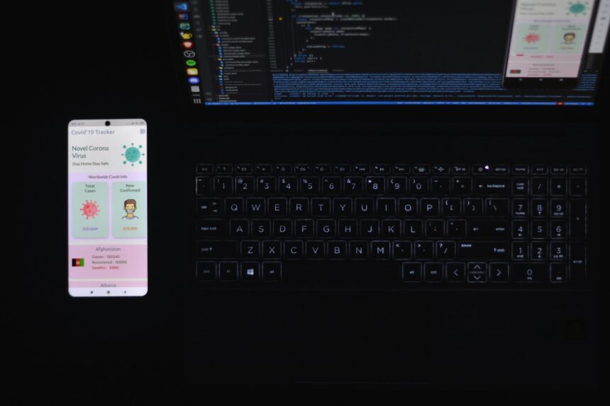 A smartphone laying next to a laptop
