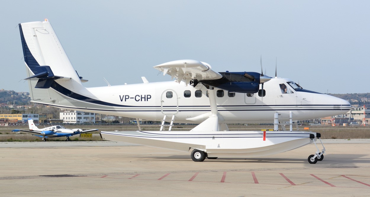 A DHC-6-400 aircraft showing lateral view and taxiing to the runway at an airport.