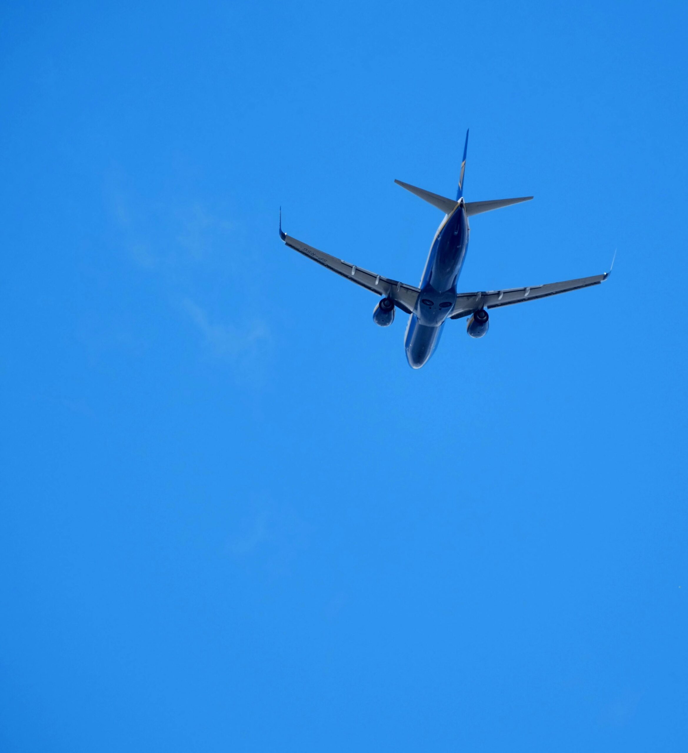 Airplane Flying High in Clear Blue Sky