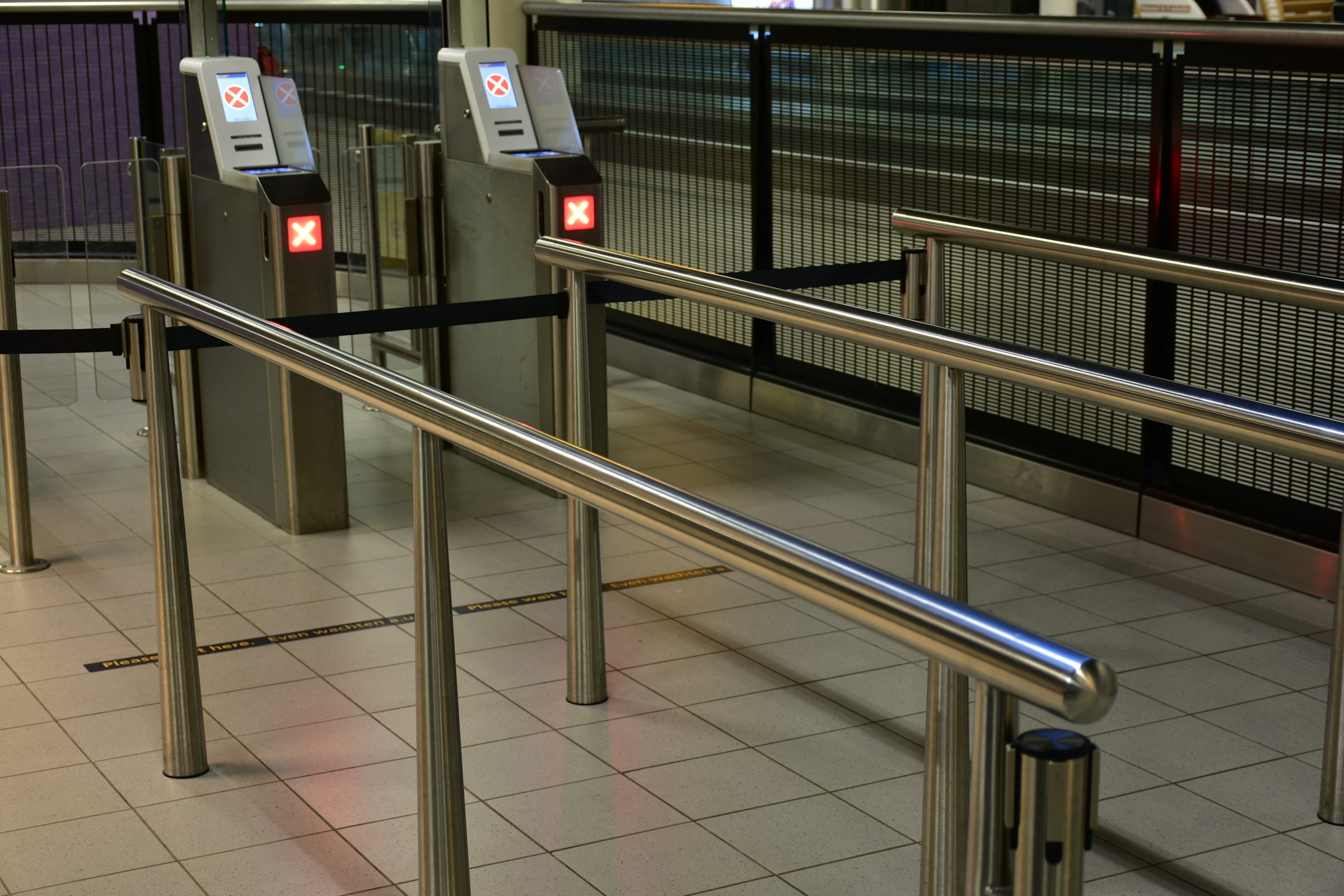 Immigration Passport Control Point, metal barriers and passport scanners.