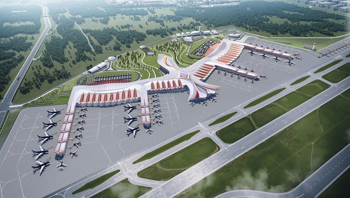 Airport model, in the shape of a Phoenix, aircrafts in apron, trees and fields in the background.