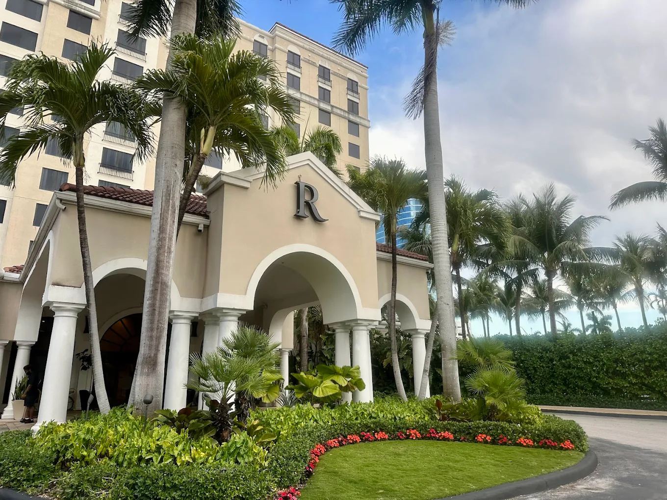 Exterior of Renaissance hotel. Palm trees and bushes in front of the building.