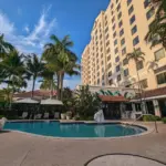 Exterior of Renaissance Hotel in Fort Lauderdale, pool and palm trees in view, blue sky.