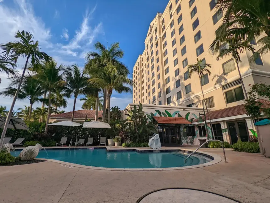 Exterior of Renaissance Hotel in Fort Lauderdale, pool and palm trees in view, blue sky.