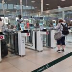 Travellers pass through automated e-gates at Lisbon Airport while border checks are carried out inside the terminal.