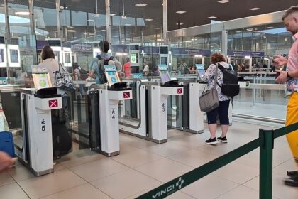 Travellers pass through automated e-gates at Lisbon Airport while border checks are carried out inside the terminal.