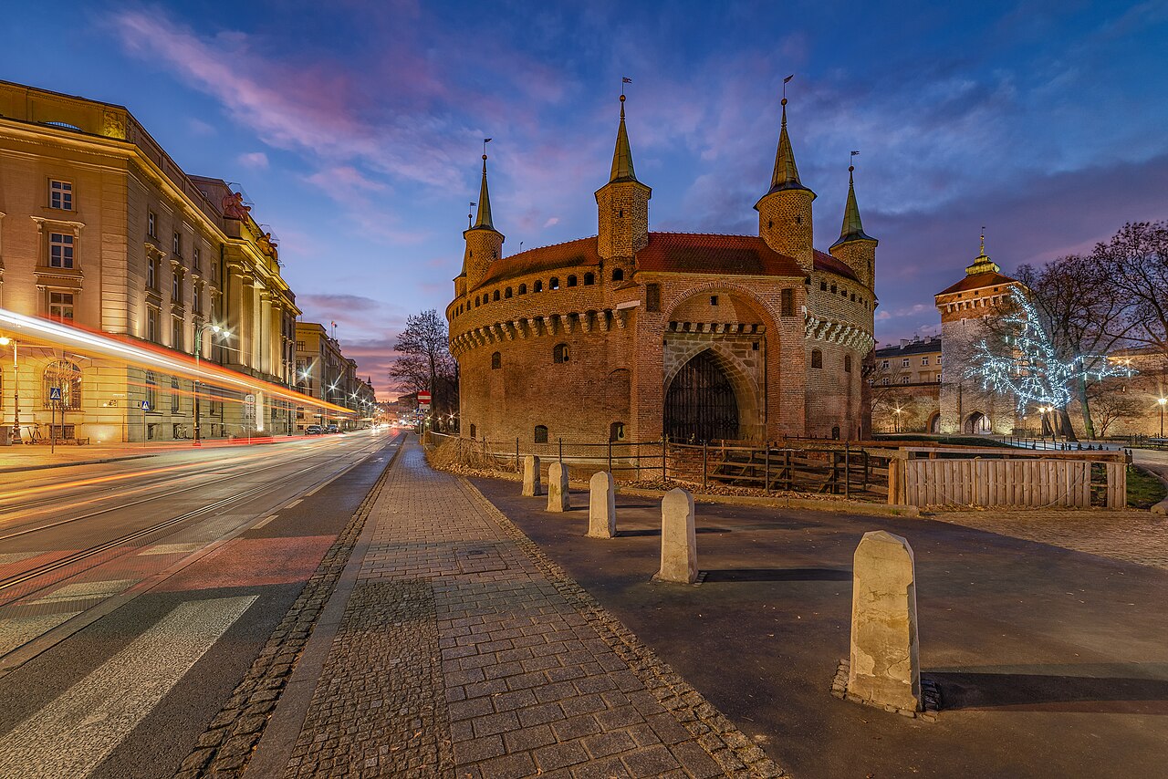 The Kraków Barbican seen at dawn, a historic circular fortified gate with surrounding moat area, located near the Old Town of Kraków, Poland.