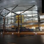 Arrivals area of GCI airport captured at night. Lights on in the building.