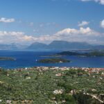 View of small green islands in the Ionian Sea near Lefkada, Greece, with calm blue water, rocky shoreline.