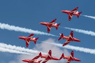 Image shows the 'Diamond Nine' Red Arrows BAe Hawk T.1A aircraft flying the '5-4 Split' manoeuvre at the Royal International Air Tattoo 2024