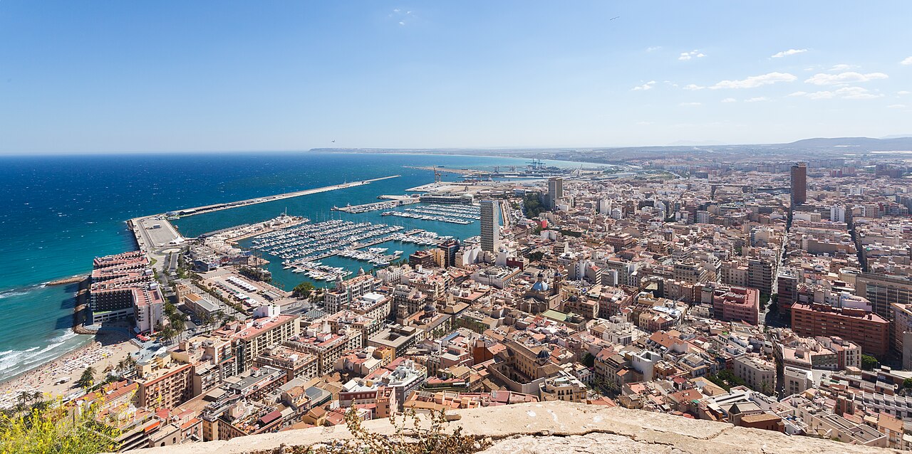 Image shows a view of Alicante, Spain with buildings, harbour and beach in 2014