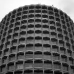 The Civil Aviation Authority UK's Head Office in London, taken from below looking up. The building occupies the whole photo, except for a strip of cloudy sky across the top and in the top corners.