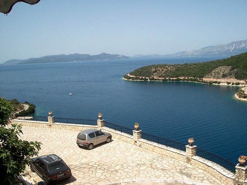 cenic view of Meganisi island from a terrace, showing coastal villages, green hills.