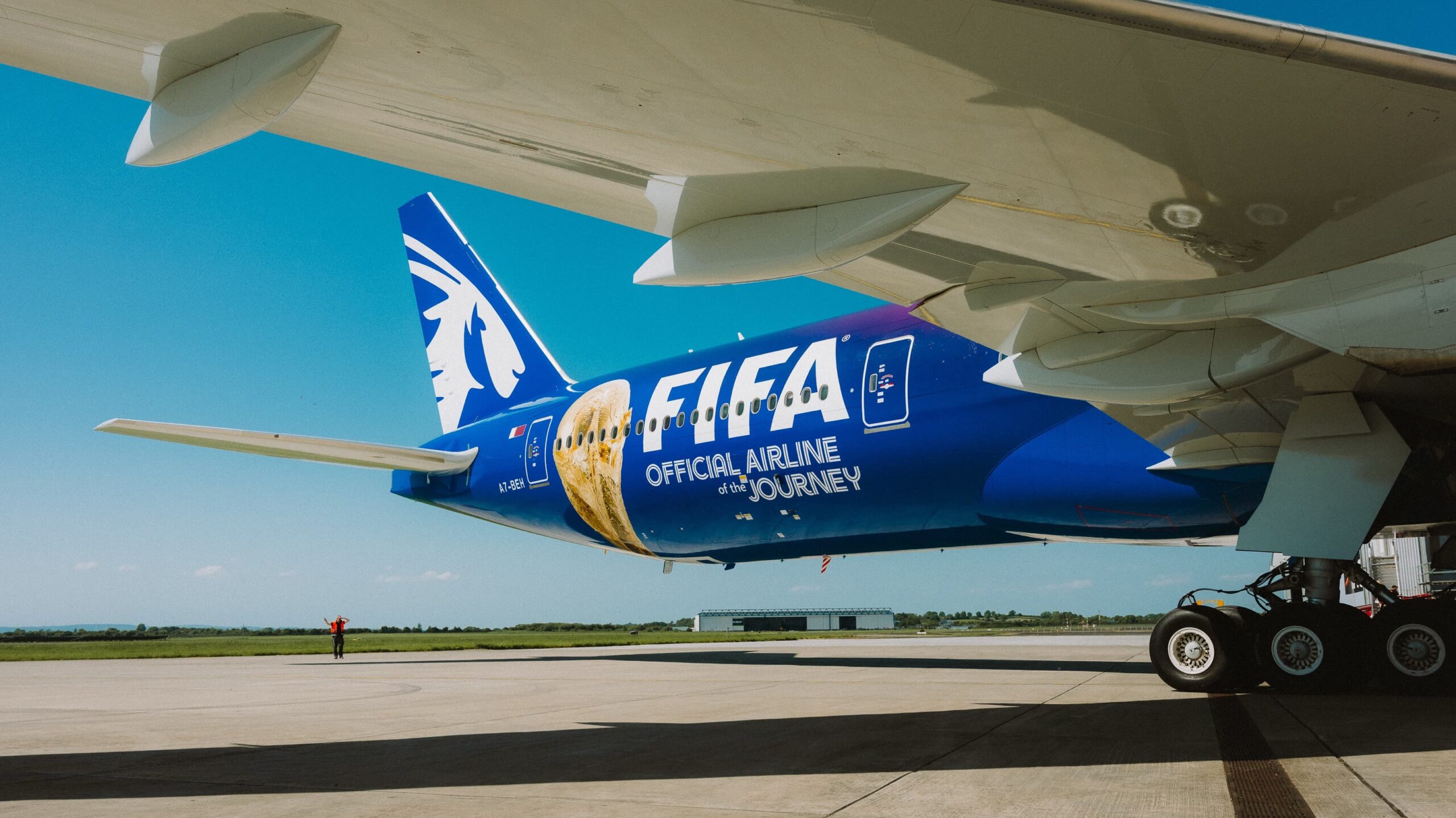 The rear end of the aircraft displaying 'FIFA official airline of the journey' in a blue colour with the FIFA trophy.