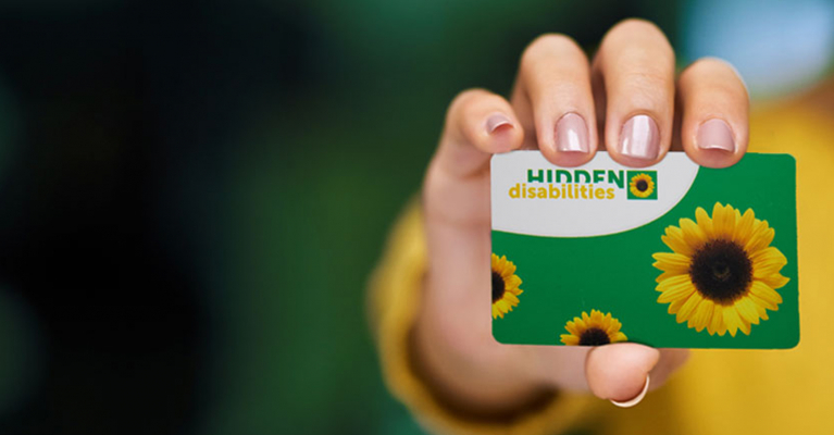 Hand holding a Hidden Disabilities Sunflower card