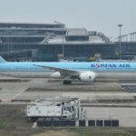 A Korean Air Boeing 787-10 in the airline’s distinctive light blue livery taxis past the terminal at Incheon International Airport, as the carrier moves toward its planned merger with Asiana Airlines in late 2026.