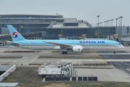 A Korean Air Boeing 787-10 in the airline’s distinctive light blue livery taxis past the terminal at Incheon International Airport, as the carrier moves toward its planned merger with Asiana Airlines in late 2026.