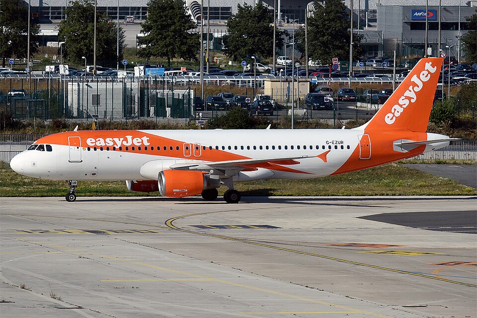 EasyJet, G-EZUR, Airbus A320-214 on the tarmac with cars in the background.