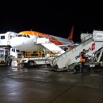 An easyJet Airbus A319 aircraft undergoes ground handling operations at night. The low-cost carrier plans to accelerate the retirement of its ageing A319 fleet as part of a wider strategy to modernise operations with newer, more fuel-efficient Airbus aircraft.