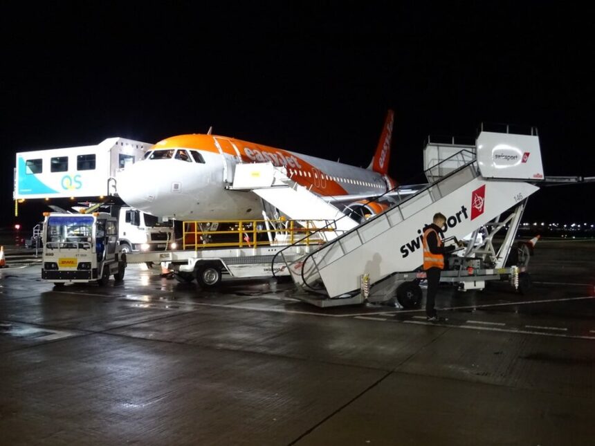 An easyJet Airbus A319 aircraft undergoes ground handling operations at night. The low-cost carrier plans to accelerate the retirement of its ageing A319 fleet as part of a wider strategy to modernise operations with newer, more fuel-efficient Airbus aircraft.