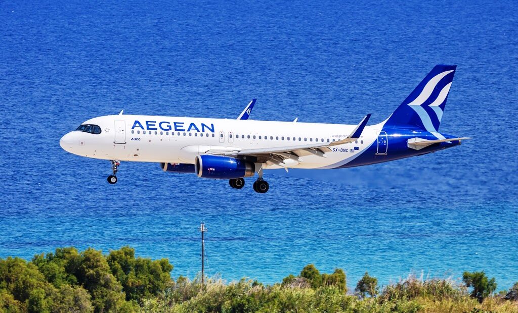 Aegean Airlines Airbus A320 airplane landing on a runway in front of ocean at Rhodes Airport in Greece