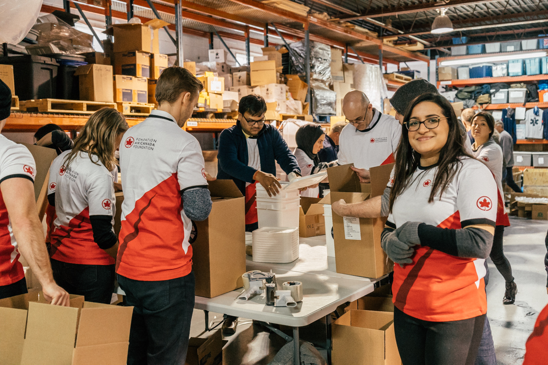 A group of Air Canada Foundation volunteers packing bags for humanitarian causes