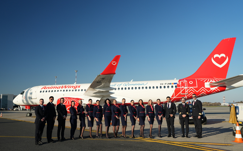 An AnimaWings A320, alongside staff on the runway