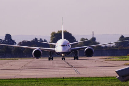 British Airways aircraft at London Heathrow Airport, on the runway before takeoff, heading towards the camera. Trees in the background.