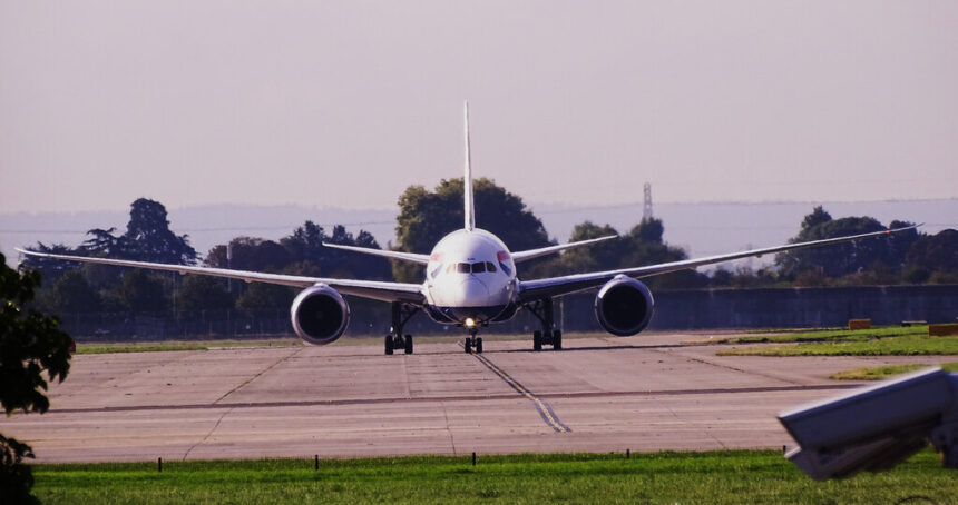 British Airways aircraft at London Heathrow Airport, on the runway before takeoff, heading towards the camera. Trees in the background.