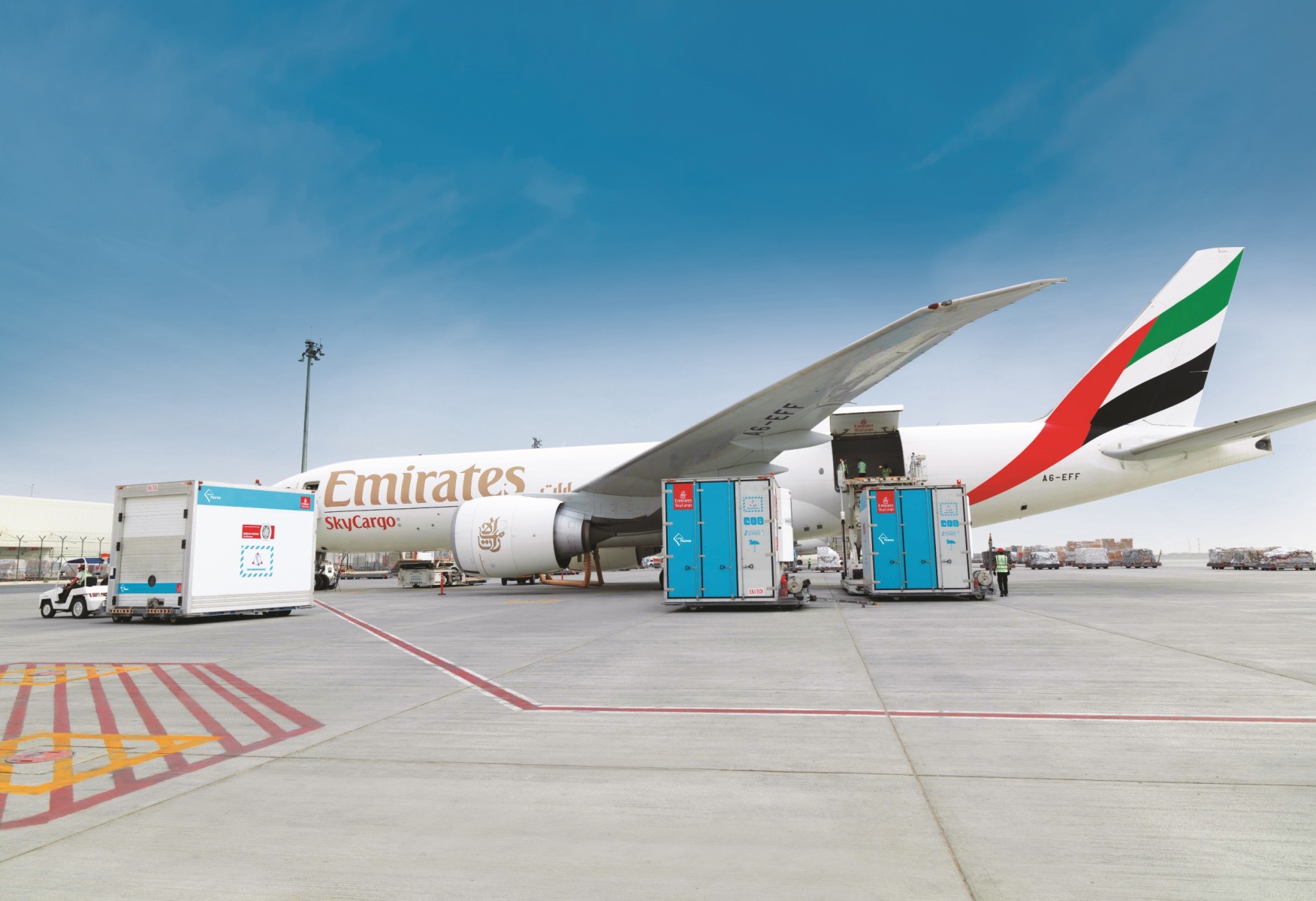 Emirates SkyCargo aircraft loading alongside warehouse operations