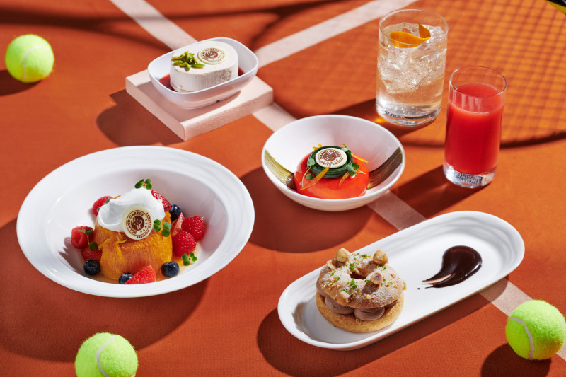Tennis-inspired desserts such as Paris-Brest and fruit tarts are shown on a Roland-Garros-themed table 