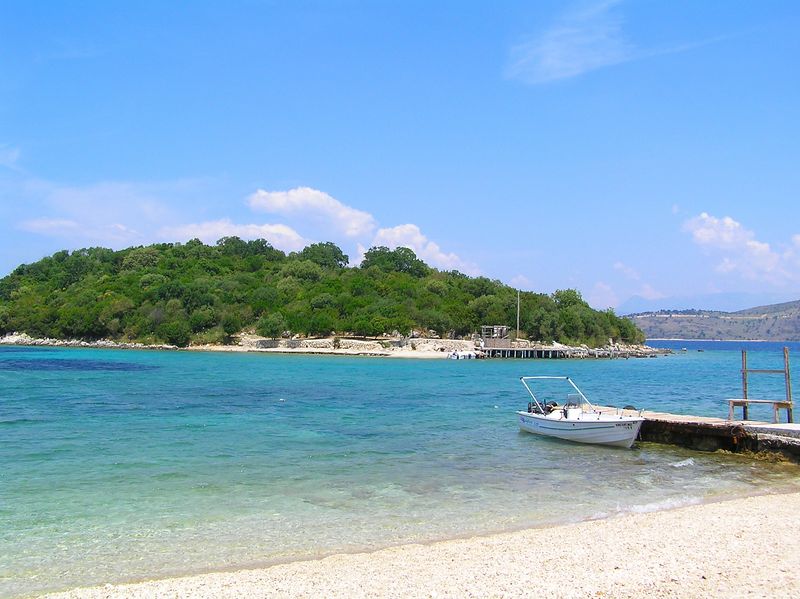 Ksamil Beach in Albania with turquoise waters, sandy shore, and small islands in the distance.
