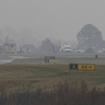 A golf course with the wreckage of a plane and a fire engine beside it