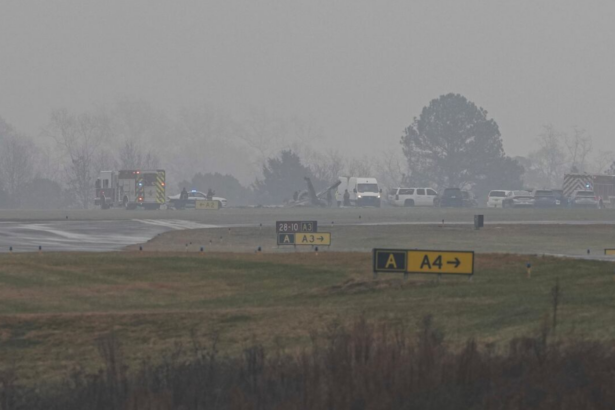 A golf course with the wreckage of a plane and a fire engine beside it