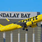A large yellow Jetliner taking off from an airport with blue sky