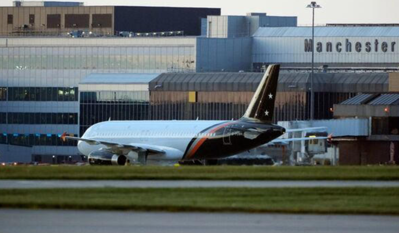 A large white jetliner sitting on the tarmac at an airport