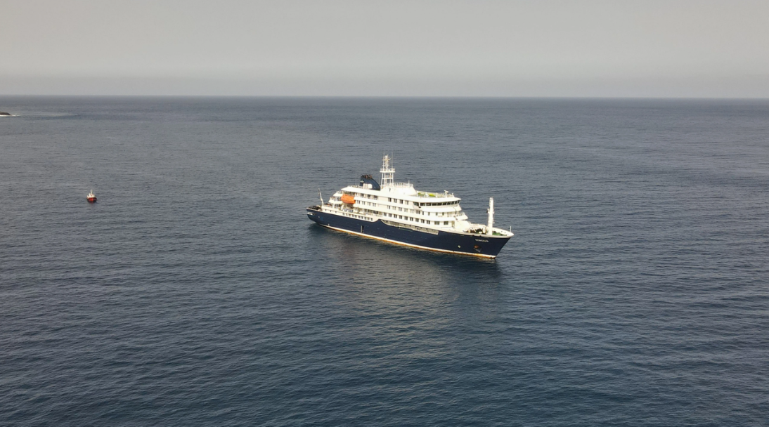 A large cruise ship floating in a blue sea