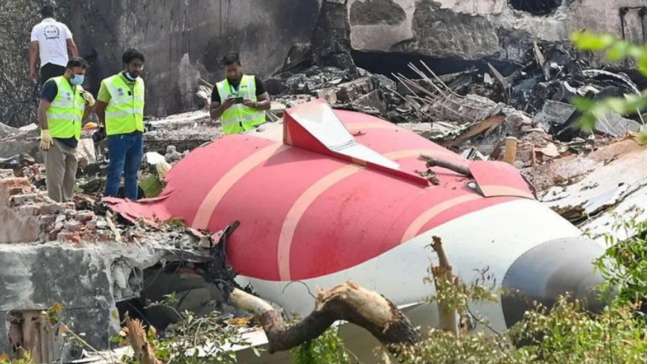 The wreckage of a red and white plane with debris around it