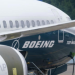 A large blue and white Boeing 737 jetliner sitting on the tarmac.